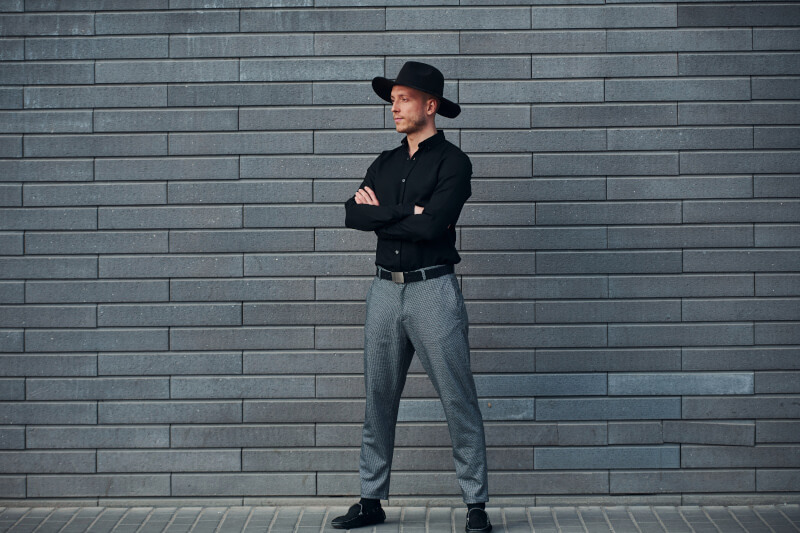 Biznesowa stylizacja męska z czarną koszulą, szarymi eleganckimi spodniami i mokasynami
