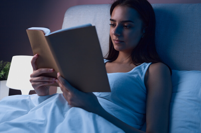 kobieta czytająca książkę w łóżku