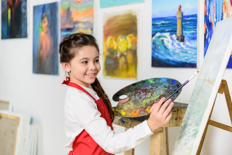 Uzdolniona plastycznie dziewczynka malująca obraz