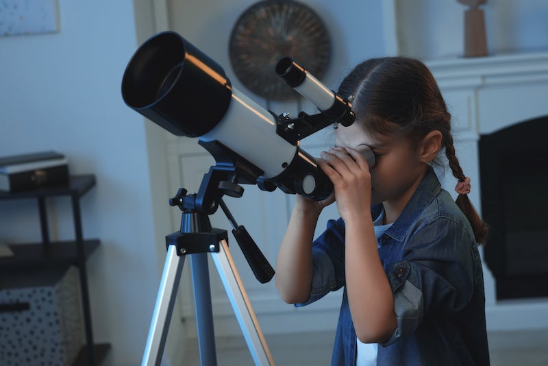 Dziewczynka patrzącą przez teleskop