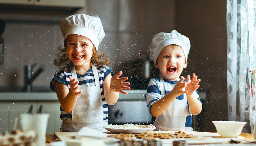 Uśmiechnięte dziecki podczas gotowania w kuchni