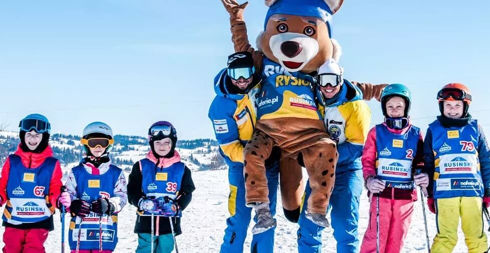 Grupa dzieci z instruktorami na nartach