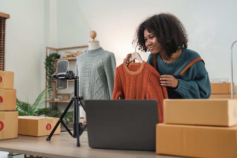 kobieta nagrywająca krótką prezentację sprzedawanego swetra