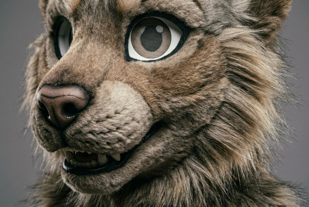 Zbliżenie na detale fursuitu: sztuczne futro, szwy i oczy z siatki w masce