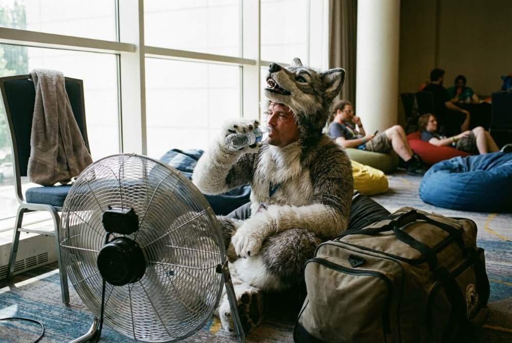 Fursuiter odpoczywa w strefie chillout, pokazując wysiłek i potrzebę przerw podczas noszenia fursuitu