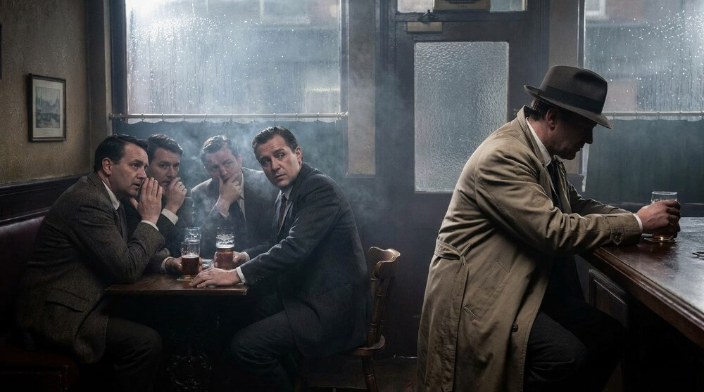 Grupa mężczyzn patrzących podejrzliwie na mężczyznę przy barze