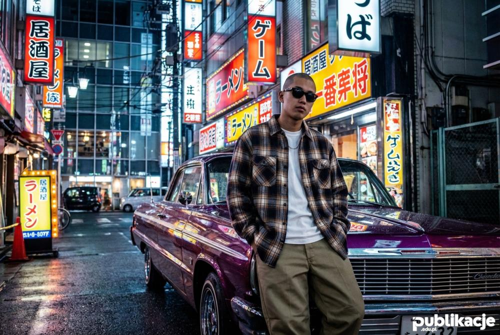 Japoński fan stylu cholo w Tokio przy lowriderze