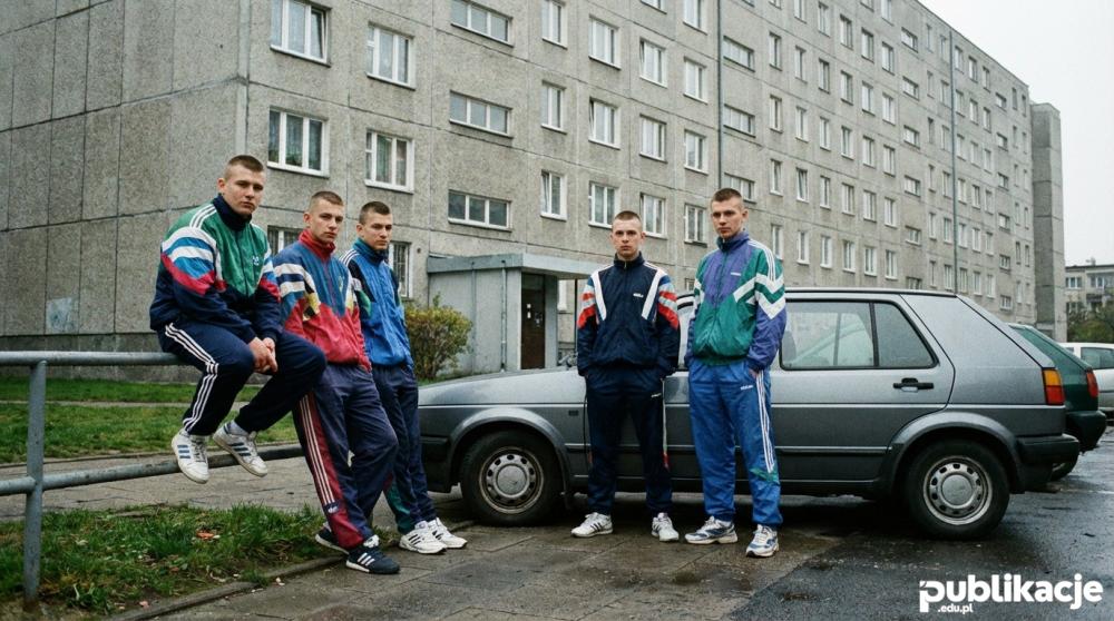 Grupa dresiarzy w ortalionowych strojach na polskim osiedlu